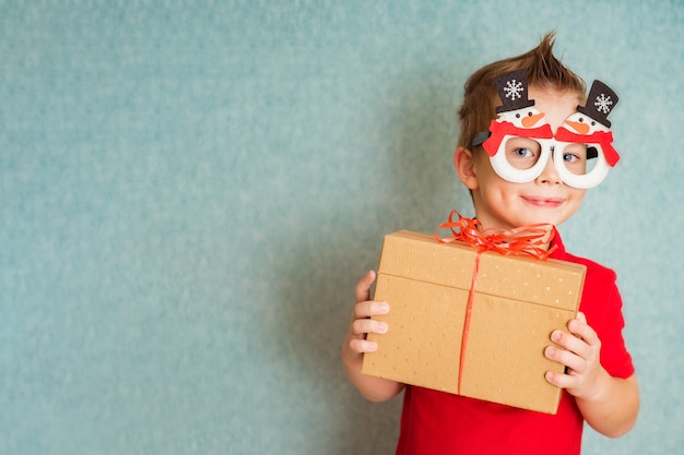 Niño feliz de santa usa gafas de fantasía. Traje festivo, accesorios de vacaciones. Navidad y Año Nuevo