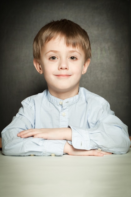 Niño feliz sentado en el aula de la escuela