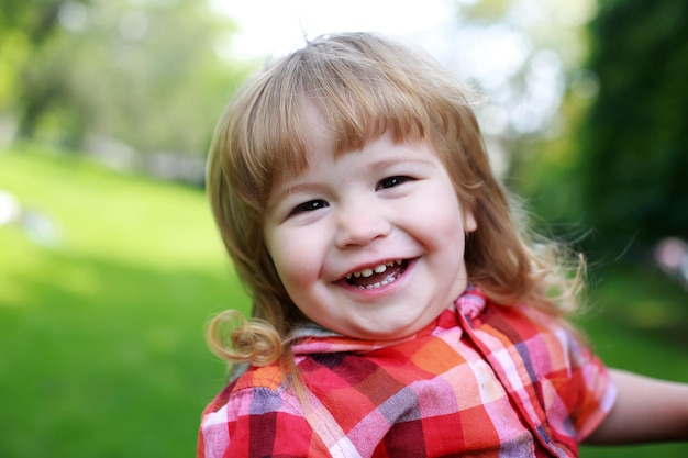 Niño feliz sobre fondo natural verde