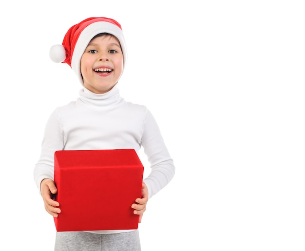 Niño feliz con sombrero de santa claus con regalo rojo