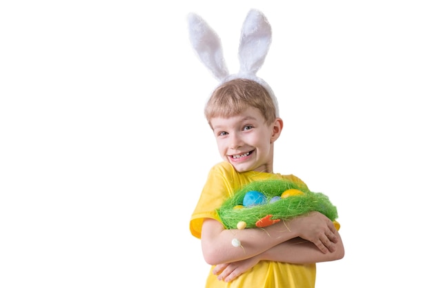 Niño feliz sonriendo en una camiseta amarilla en orejas de conejo y con coloridos huevos Concepto de Pascua