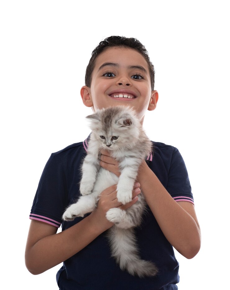 Niño feliz sonriendo con gatito peludo