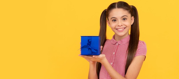 Niño feliz sostenga el cuadro actual sobre fondo amarillo Niño niña con cartel horizontal de regalo Encabezado de banner con espacio de copia