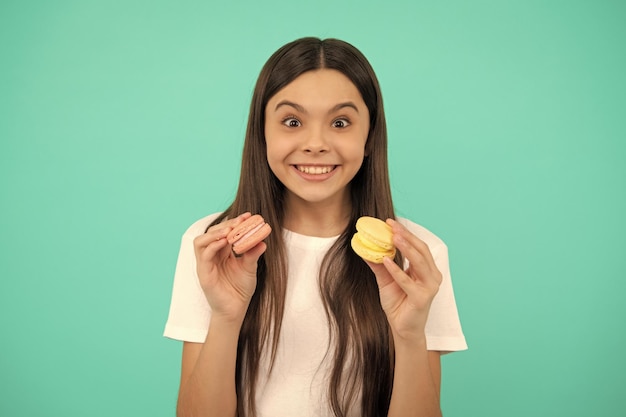 Niño feliz sostenga macaron francés o galletas macaron macaron