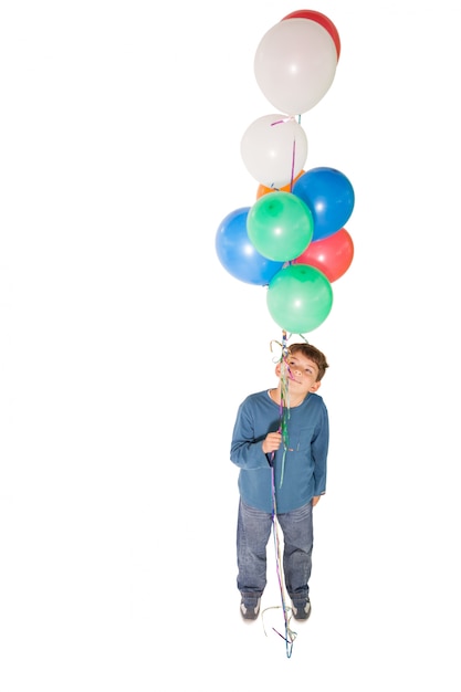 Niño feliz sosteniendo un montón de globos