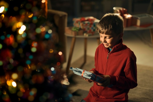 Niño feliz sosteniendo un regalo de Navidad