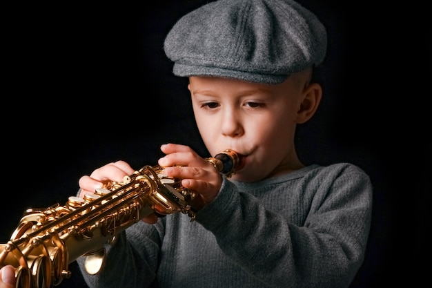 Niño feliz toca el saxofón en estudio