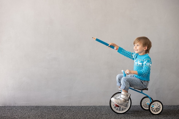 Niño feliz con traje de Navidad Niño montando bicicleta concepto de vacaciones de Navidad