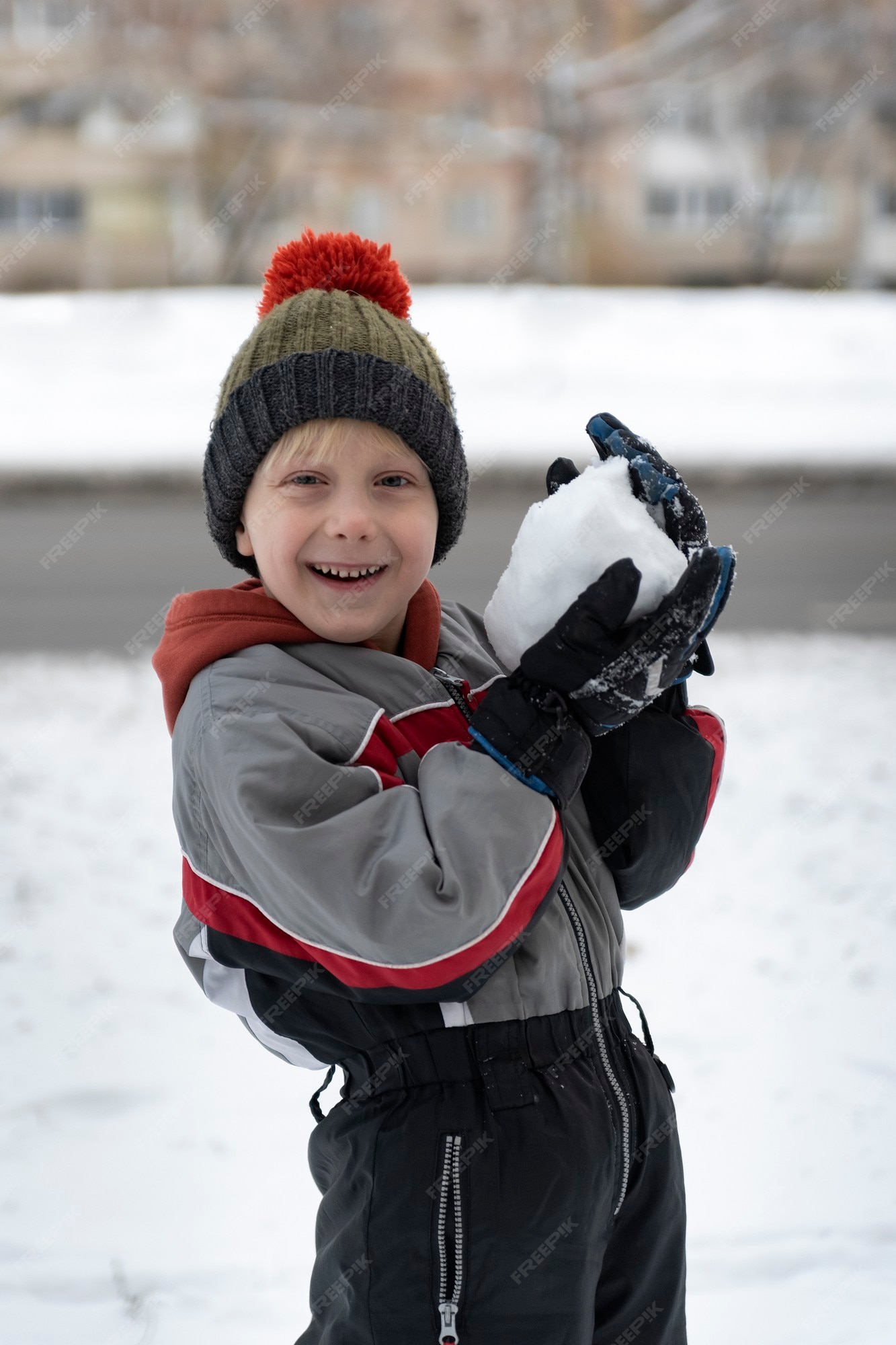 Menos para castigar disparar Niño feliz en traje de nieve juega bolas de nieve. retrato de niño al aire  libre en invierno. | Foto Premium