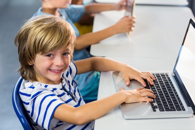 Niño feliz usando laptop