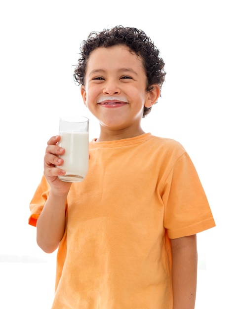 Niño feliz con un vaso de leche sobre fondo blanco.