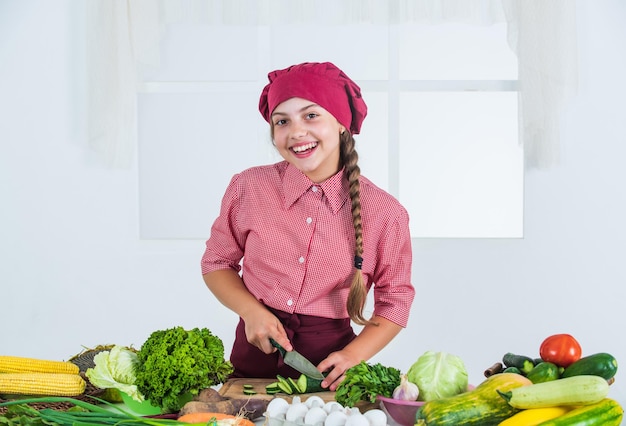 Niño feliz con verduras coloridas en la cocina comida saludable