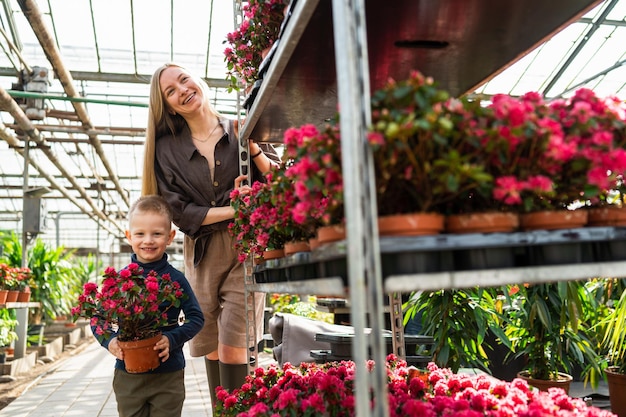 Niño con flor en maceta y su mamá