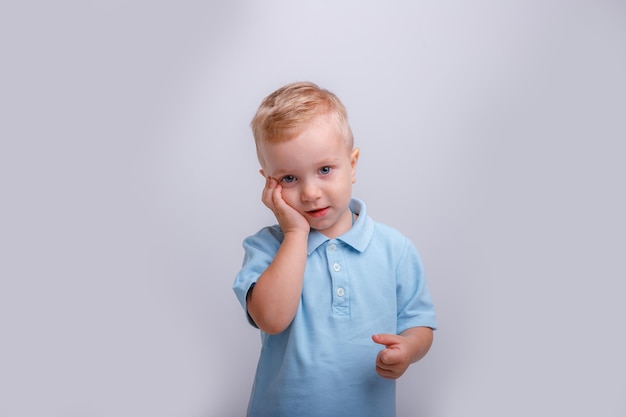 Un niño de fondo blanco en un estudio de camisa azul