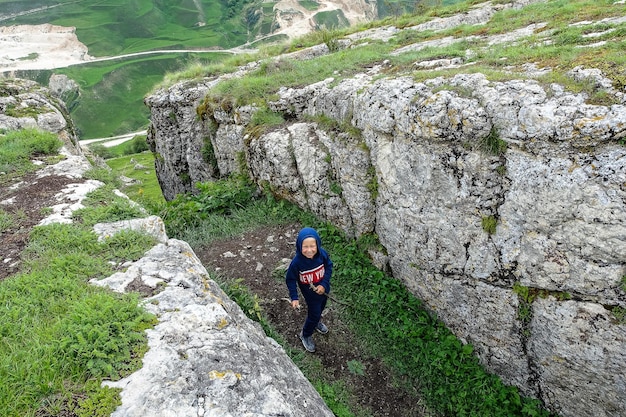 Un niño en el fondo de un paisaje de montaña en las nubes Cuenco de piedra en Daguestán Rusia