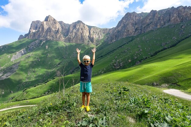 Un niño en el fondo del paisaje verde del paso de Aktoprak en el Cáucaso Rusia junio de 2021