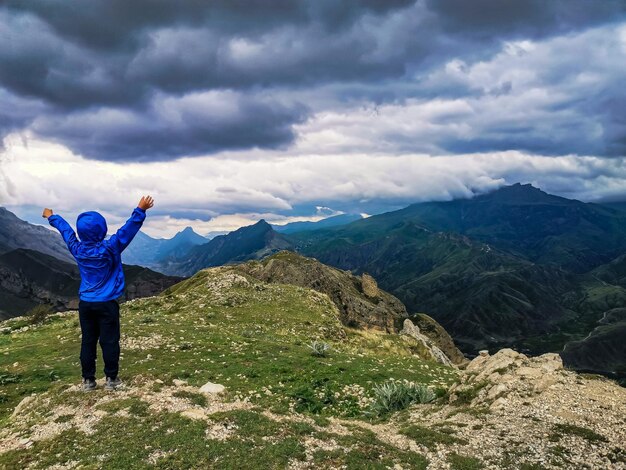 Un niño en el fondo de una vista impresionante de las montañas durante una tormenta en Daguestán Cáucaso Rusia