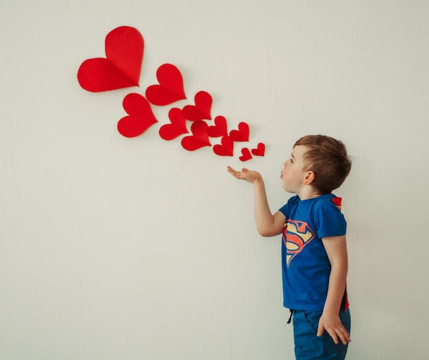 Foto niño con forma de corazón contra la pared