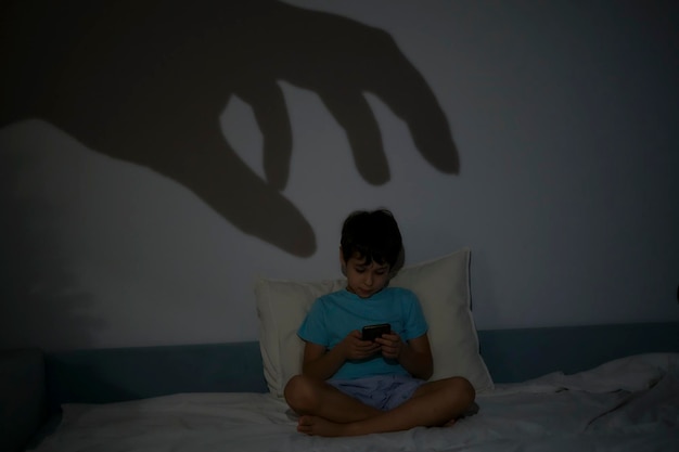 Foto niño frustrante buscando aburrido jugando al teléfono niño somnoliento jugando al móvil acostado en el