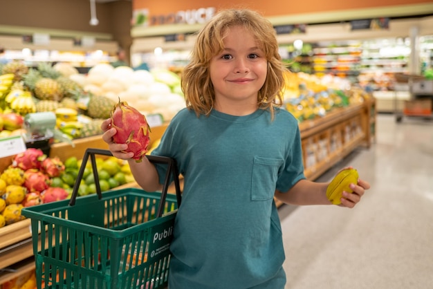 Niño con frutas comprando en el supermercado niños comprando comestibles en el supermercado niño pequeño compre ve fresco