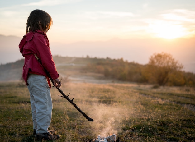 Niño con fuego en la naturaleza