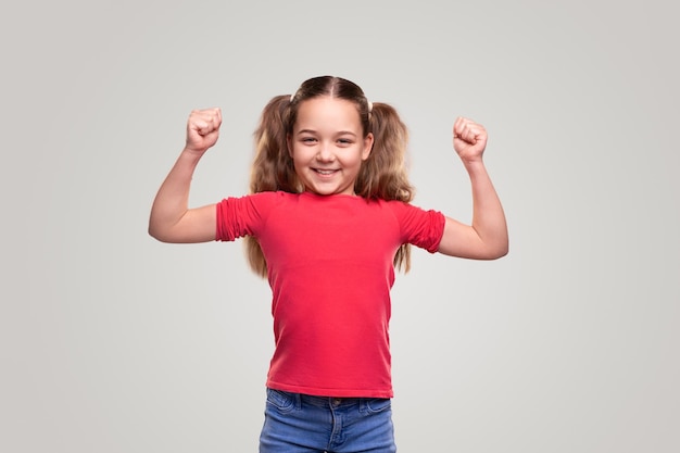 Niño fuerte sonriendo y mostrando bíceps