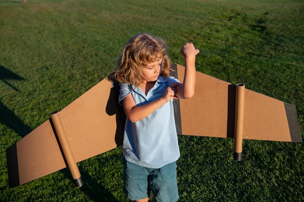 Niño fuerte superhéroe niño muestra músculos éxito motivación concepto niño piloto jugar en el día de verano