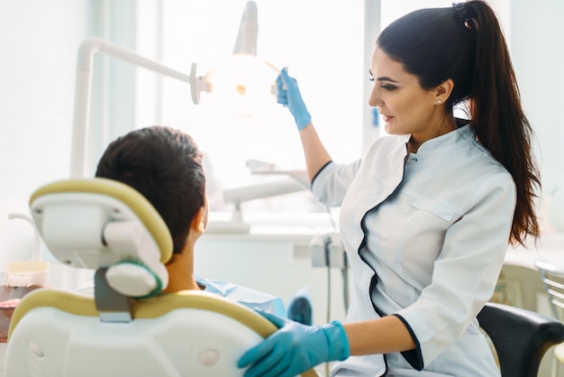 Niño en un gabinete dental, odontología pediátrica. El médico examina los dientes de un paciente pequeño.