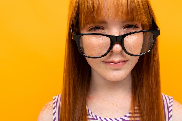 Niño con gafas de fondo amarillo para ver el retrato de primer plano