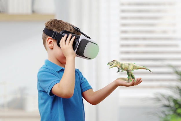 Niño con gafas VR proyecta un dinosaurio en su brazo El concepto de usar la realidad virtual en la educación