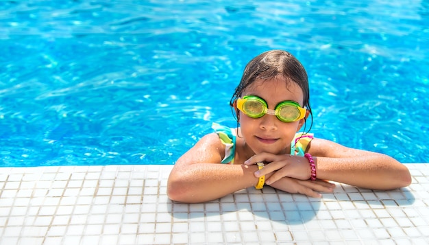 Un niño con gafas se zambulle en la piscina. Enfoque selectivo.