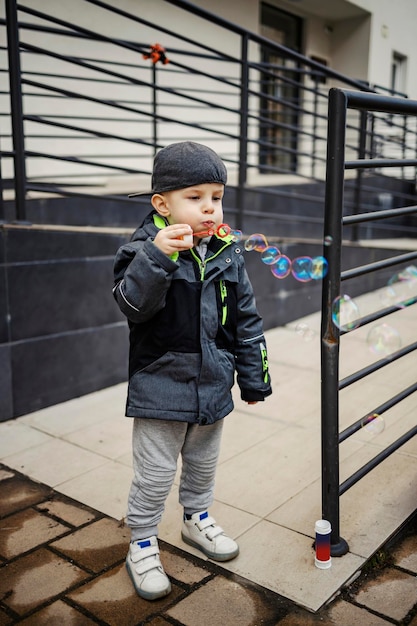 Un niño genial jugando con burbujas afuera