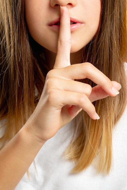 Foto niño gesto de silencio secreto mantener silencio niña shhh