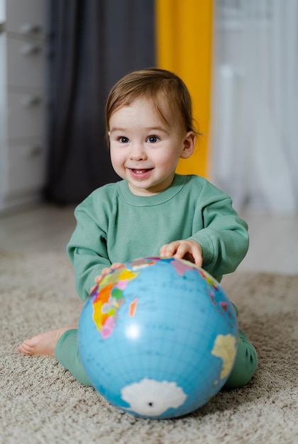 Niño con el globo geográfico Niño explorando el mundo