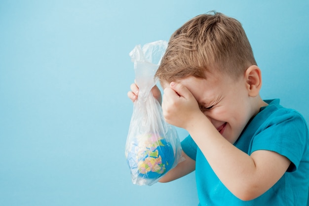 Niño con un globo en un paquete sobre un fondo azul.