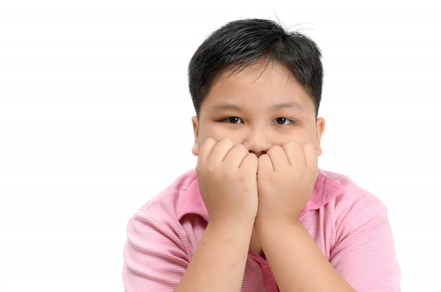 Niño gordo obeso mordiendo las uñas aisladas