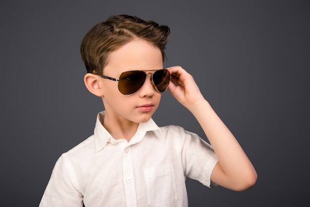 Niño gracioso joven en camisa blanca con gafas