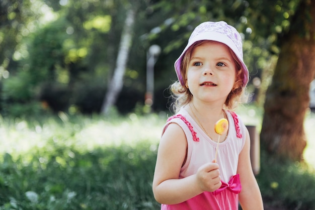 Niño gracioso con paleta de caramelo, niña feliz comiendo grande