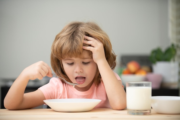 Niño gracioso con plato de sopa infantil cena