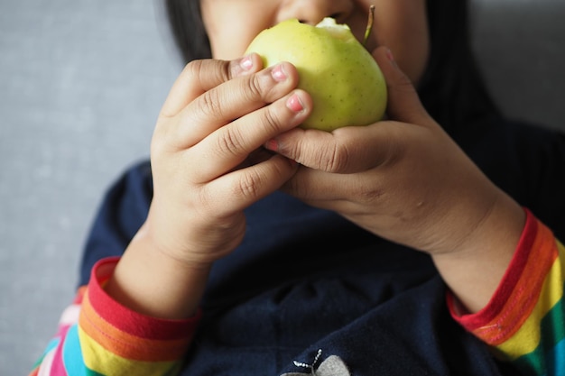 Un niño con una gran manzana en las manos.