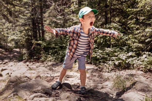 Niño gritando representa a un dinosaurio malvado en el bosque