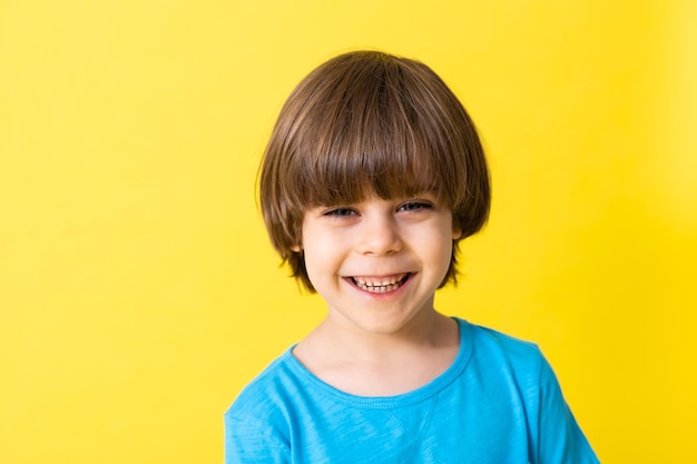 Niño guapo en camisa azul espacio de banner de fondo amarillo para texto