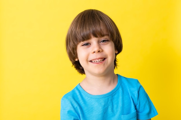 Niño guapo en camisa azul espacio de banner de fondo amarillo para texto