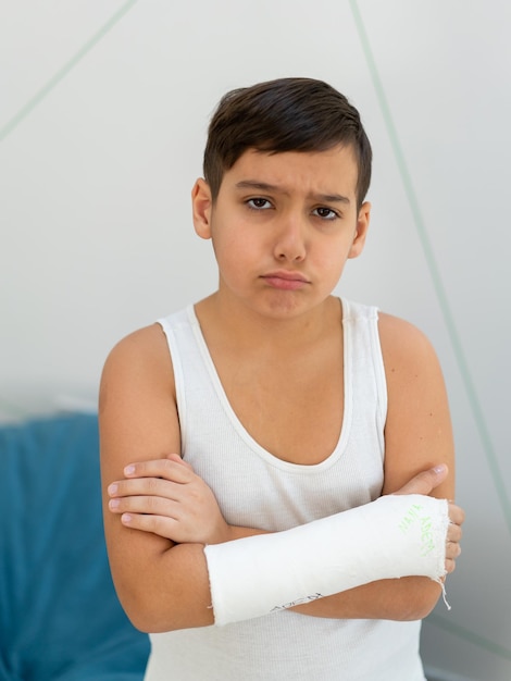 Foto niño guarda brazo roto en yeso accidente de brazo en casa lesión trauma concepto foto de alta calidad