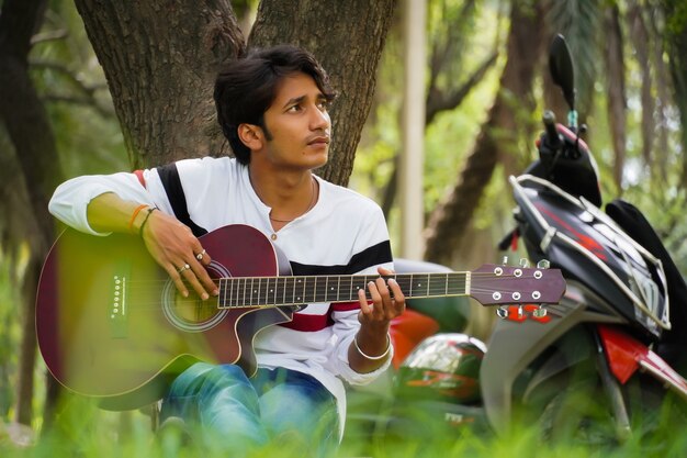 Niño con guitarra roja con bicicleta roja