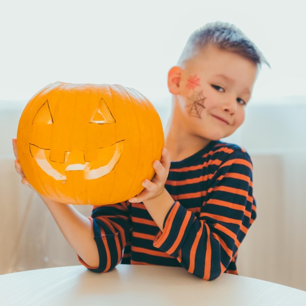 Niño hace cabeza de calabaza de halloween en casa