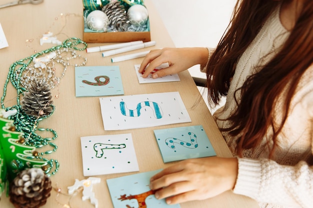 Foto un niño hace un calendario de adviento navideño con papel con sus propias manos bricolaje de cerca