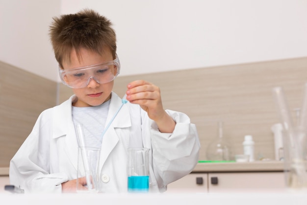 Foto niño haciendo un experimento en la escuela.