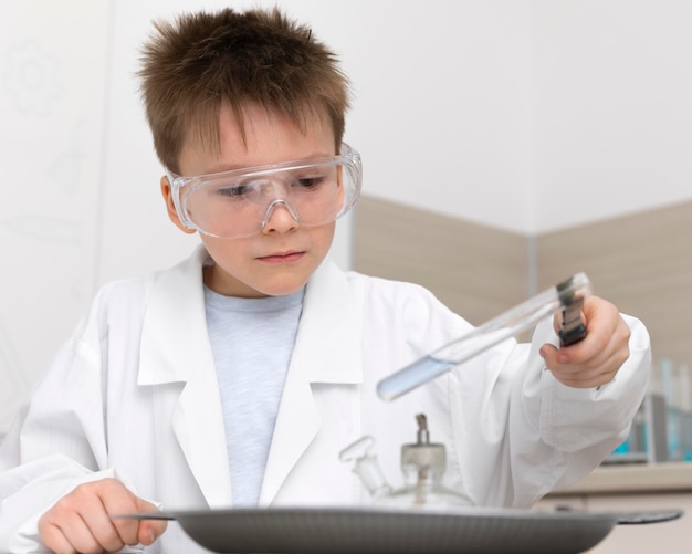 Foto niño haciendo un experimento en la escuela.