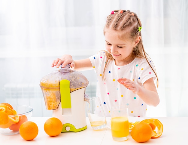 Niño haciendo jugo de naranja